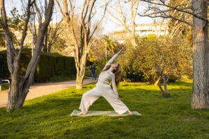 claudia practicando yoga en un parque rodeada de arboles en barcelona